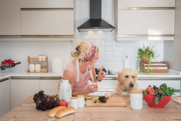 istock Woman with her dog making breakfast in the kitchen. 1274850732