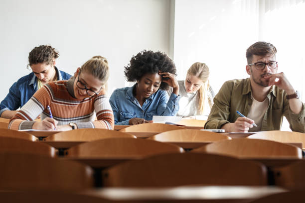 istock Group of university students taking a test in a classroom. 1274853309