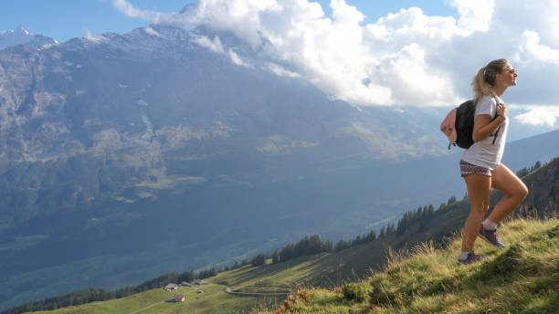 istock Young woman hikes through alpine meadow, at sunrise 1274854749