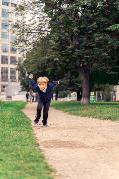 istock boy 5 years old runs fast like an airplane, hands back like wings 1274857012