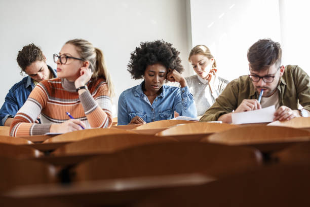 istock Group of university students taking a test in a classroom. 1274857058