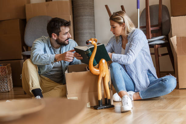 istock Married couple unpacking cardboard boxes at new home. 1274866675