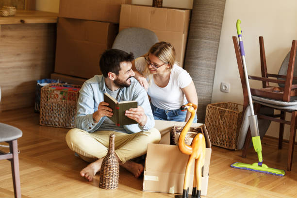 istock Married couple unpacking cardboard boxes at new home. 1274867125