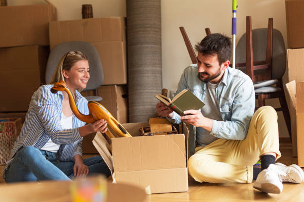 istock Married couple unpacking cardboard boxes at new home. 1274867129