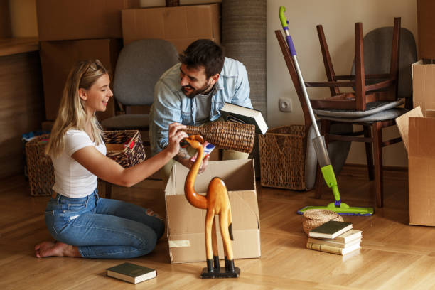 istock Married couple unpacking cardboard boxes at new home. 1274867434