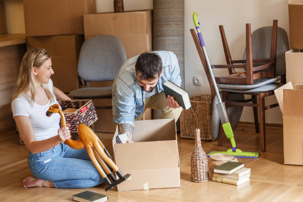 istock Married couple unpacking cardboard boxes at new home. 1274867510