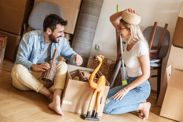 istock Married couple unpacking cardboard boxes at new home. 1274867884