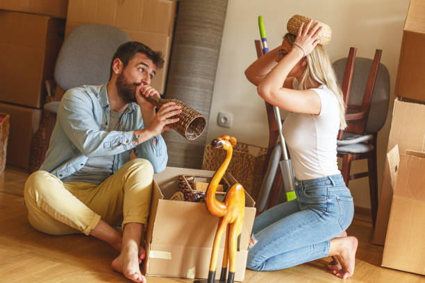 istock Married couple unpacking cardboard boxes at new home. 1274867959