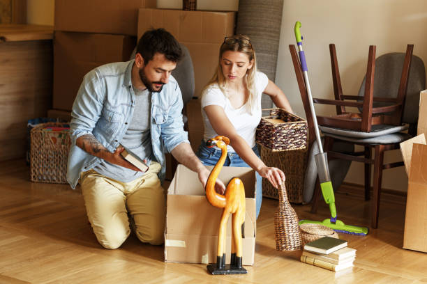 istock Married couple unpacking cardboard boxes at new home. 1274868122