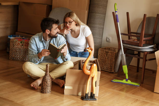 istock Married couple unpacking cardboard boxes at new home. 1274868519