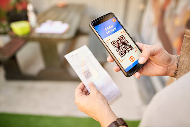 istock Woman paying for a purchase using a QR scanner on her smart 1274869058