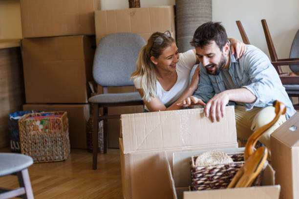 istock Married couple unpacking cardboard boxes at new home. 1274869244