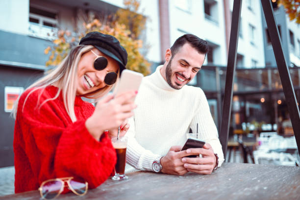 coppia che beve caffè ed esplora i social media insieme - couple blond hair social gathering women foto e immagini stock