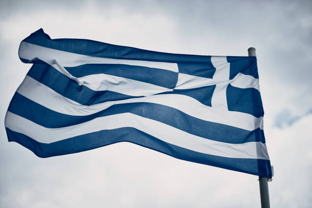 istock Low Angle View Of Greek Flag Against Overcast Cloudy Sky 1274898822