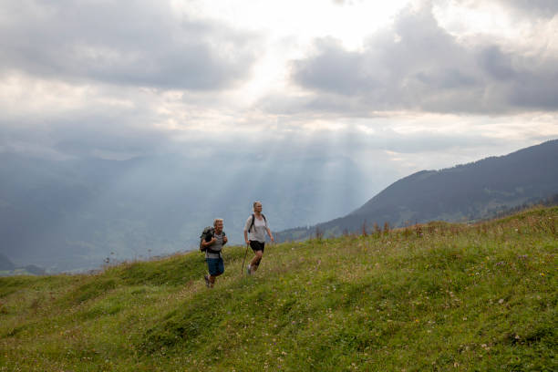 istock Mature couple hike through alpine meadow, at sunrise 1274899779