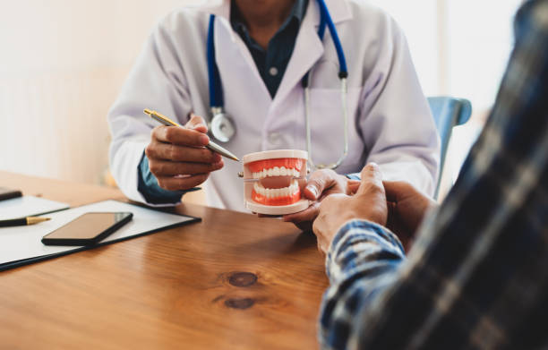 il paziente sta ascoltando una spiegazione dal dentista. i dentisti stanno spiegando e dando consigli su come prendersi cura dei denti. - dentist dentist office patient discussion foto e immagini stock