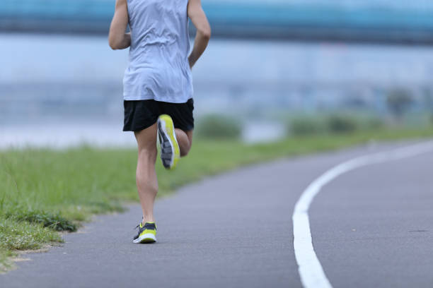 istock Man jogging on city park road 1274909770