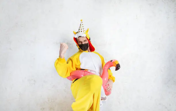 Happy young man in yellow pejamas. Winner! Concept of a party at home