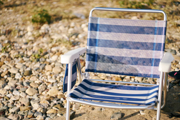 istock Foldable Beach Chair On Greek Rocky Beach At Sunset 1274922732