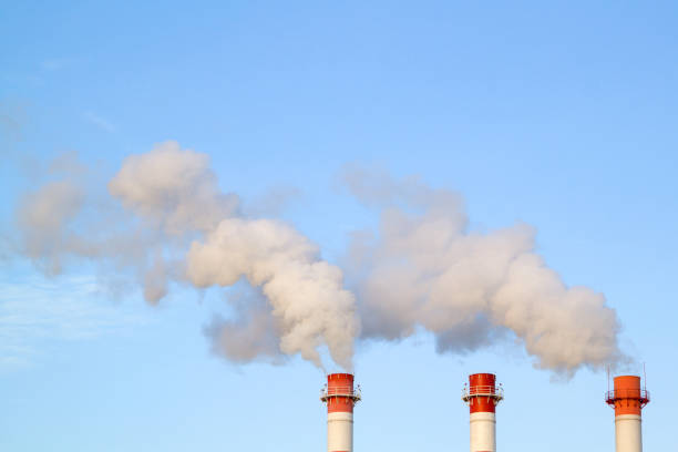 fumando pilhas industriais em uma usina térmica emitem ar poluído na atmosfera no céu azul - pollution smoke stack air pollution smoke - fotografias e filmes do acervo