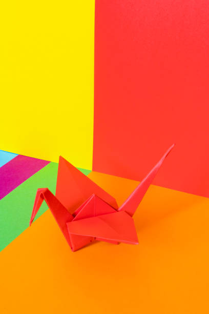 istock Red paper origami bird on a colorful background. 1274925465