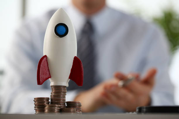 istock Macro photo on little rocket that standing on coins 1274928981