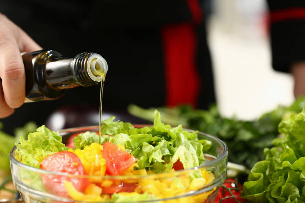 istock Young chef pouring down olive oil into salad 1274929069