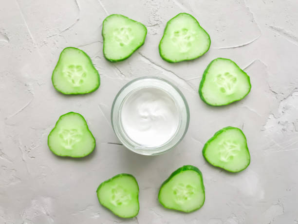 istock Cream on a textured background, with cucumbers. Cucumber-based cosmetics. Natural cosmetic. Moisturizing cream. 1274935456