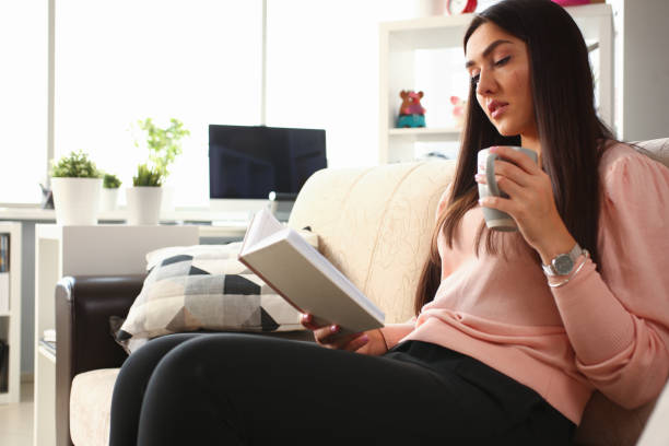 istock Relaxed young brunette girl reading interesting book 1274939339