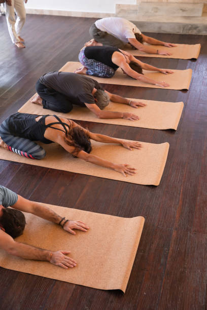 istock Group of diverse sporty multiethnic people practicing yoga lesson with instructor, sitting in Utthita Balasana exercise- Extended Child pose. Healthcare and wellness concept 1274953414