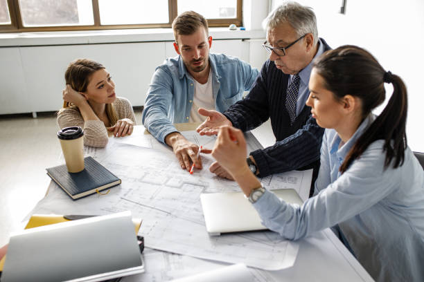 istock Group of architecture students examining blueprint . 1274957280