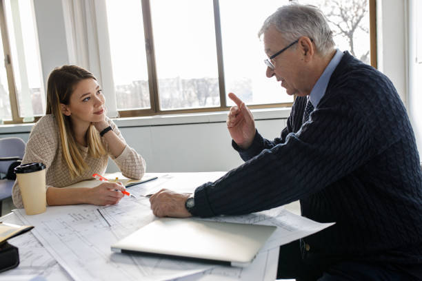 istock Two female college students listen to professor's lecture in class room. 1274957764