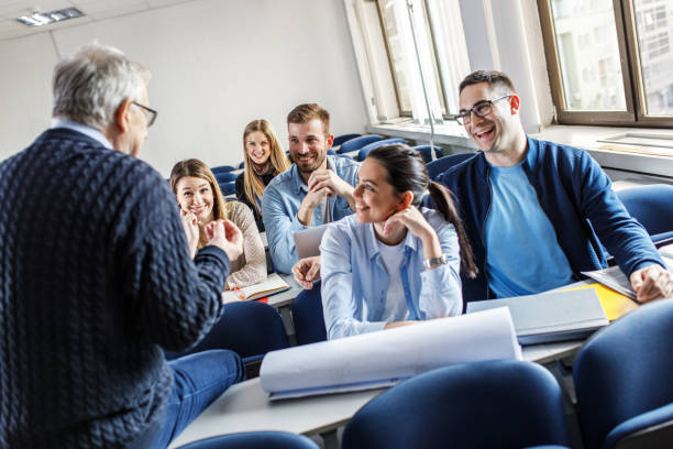 istock College students listen to professor's lecture in class room. 1274958529