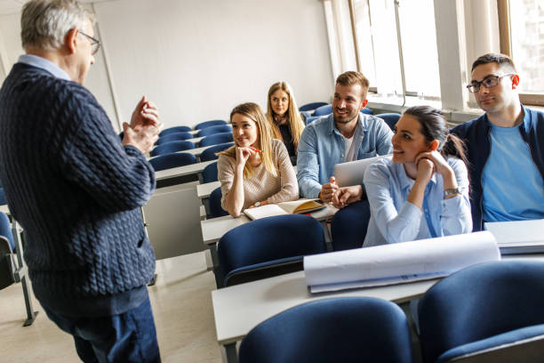 istock College students listen to professor's lecture in class room. 1274958903