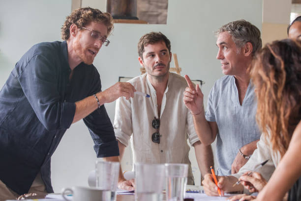 istock Happy diverse multiethnic business team talking, discussing and brainstorming on project paperwork at meeting, seminar or presentation in birght light office 1274962398
