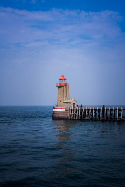 istock Lighthouse on the pier. Blue sky an blue sea 1274962732