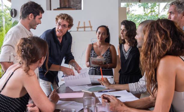 istock Happy diverse multiethnic business team members talking, discussing and brainstorming on project paperwork at meeting, seminar or presentation outdoor in tropical conference. 1274965321