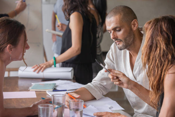 istock Happy diverse multiethnic business team talking, discussing and brainstorming on project paperwork at meeting, seminar or presentation in birght light office 1274966298
