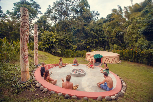 Group of people preparing for Mayan Temazcal- traditional steam sauna bath of Mesoamerican cultures. Diverse multiethnic friends taking training course before Temazcal experience grupo de personas que se preparan para temazcal maya- baño tradicional de sauna de vapor de las culturas mesoamericanas. diversos amigos multiétnicos sentados en el césped y tomando el curso de entrenamiento antes de la experiencia de temazcal
