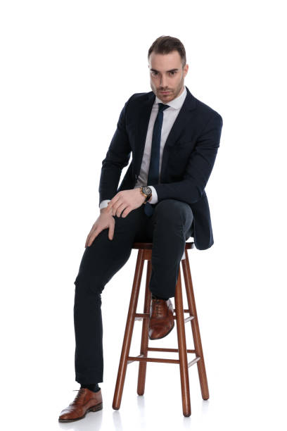 istock Tough businessman leaning on his leg, sitting on a stool 1274976943