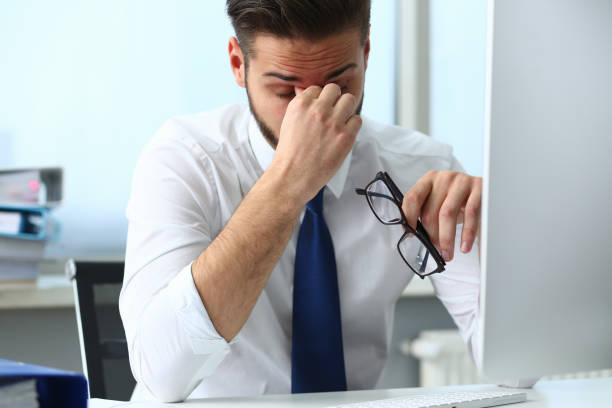 istock Tired young office worker massaging his eyes 1274978183