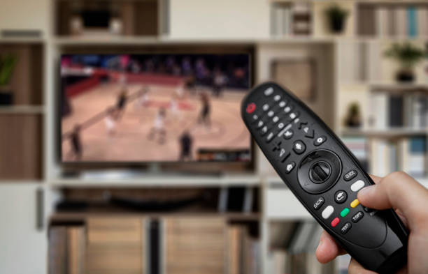 istock Watching basketball with remote control in hand 1274979201