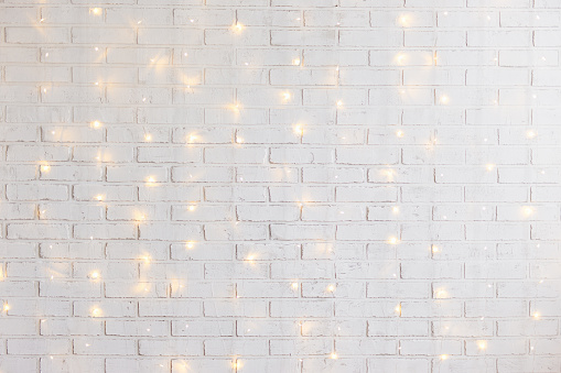 white brick wall christmas background with shiny lights