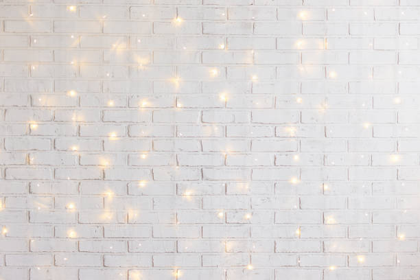 white brick wall background with shiny lights white brick wall christmas background with shiny lights floral garland photos stock pictures, royalty-free photos & images