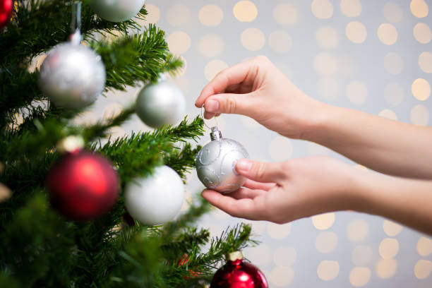 istock christmas background - woman decorating christmas tree 1274989441