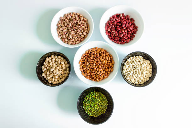 Phaseolus. Bright multi-colored beans, mung beans and chickpeas in ceramic cups.