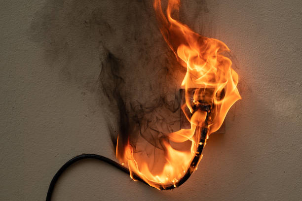 On fire electric wire plug Receptacle on the concrete wall exposed concrete background with copy space