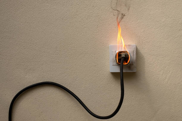 On fire electric wire plug Receptacle on the concrete wall exposed concrete background with copy space On fire electric wire plug Receptacle on the concrete wall exposed concrete background with copy space burning house stock pictures, royalty-free photos & images