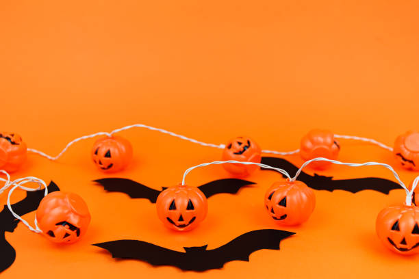 istock Orange background with halloween decorations. Scary pumpkins. 1275009726