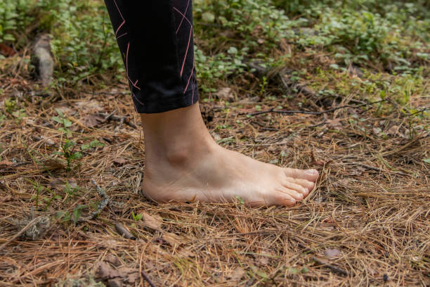 istock A woman stands barefoot on old pine needles in the forest 1275009743